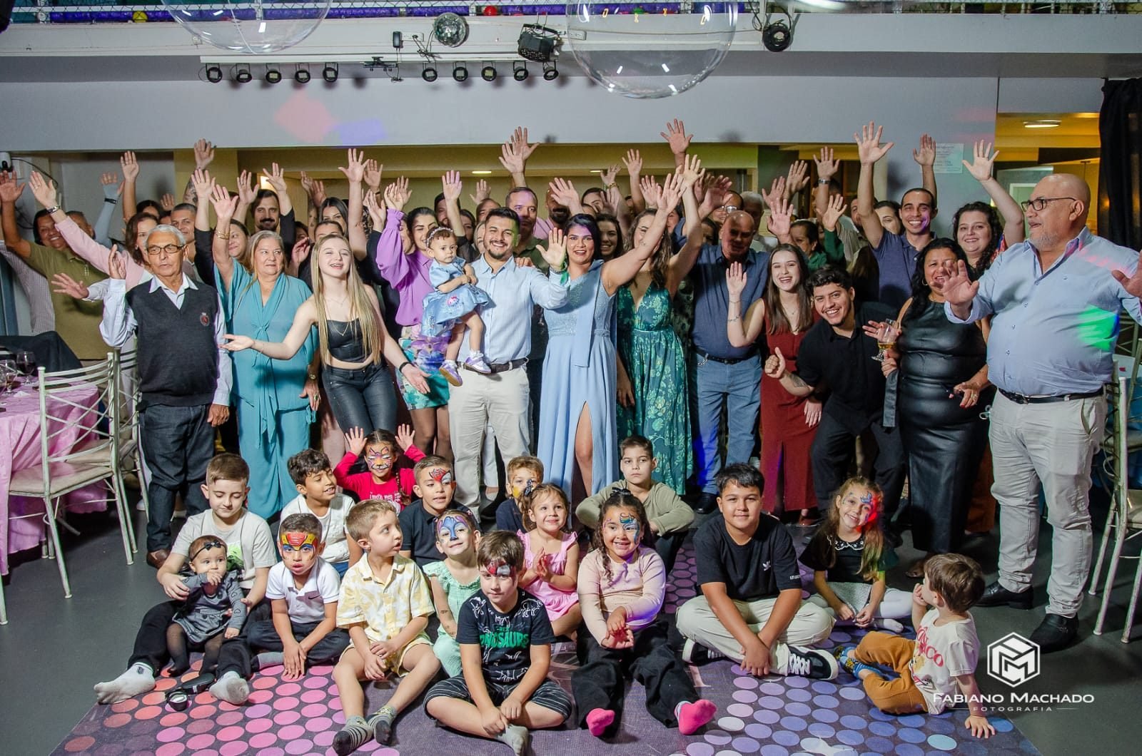 Grupo grande de família reunido comemorando numa festa noturna na FesThay