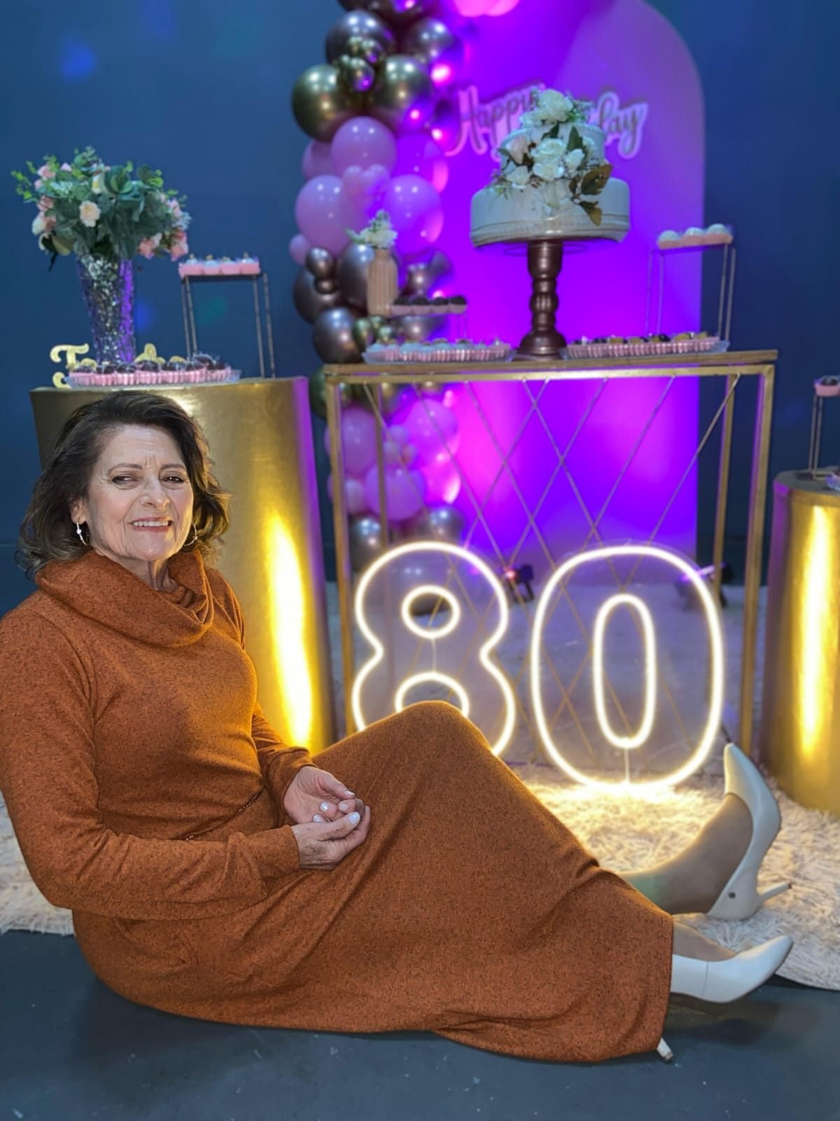 Aniversariante da melhor idade em festa de 80 anos montada na FesThay com painel e bolo