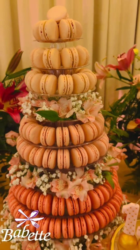 Torre de macarons montada pela Babette, cercada de arranjo floral