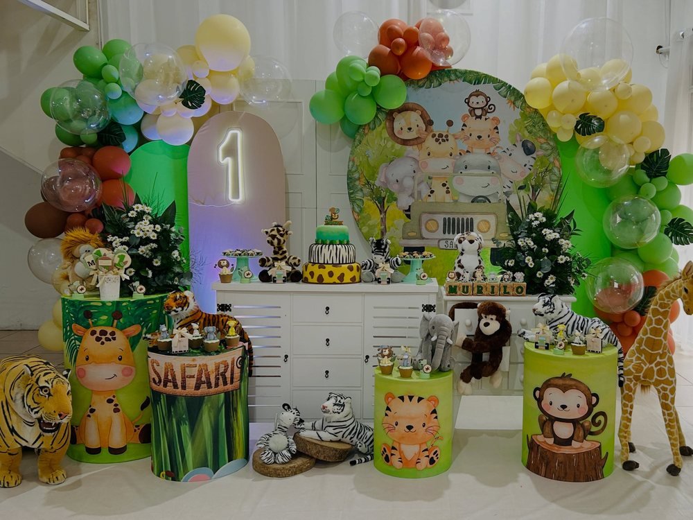 Decoração de festa tema safári com balões verdes e animais de pelúcia
