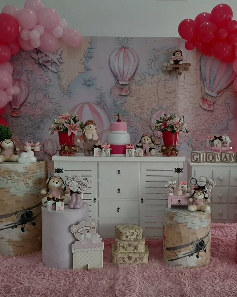 Decoração de festa com ursinho, balão de ar quente e balões vermelhos