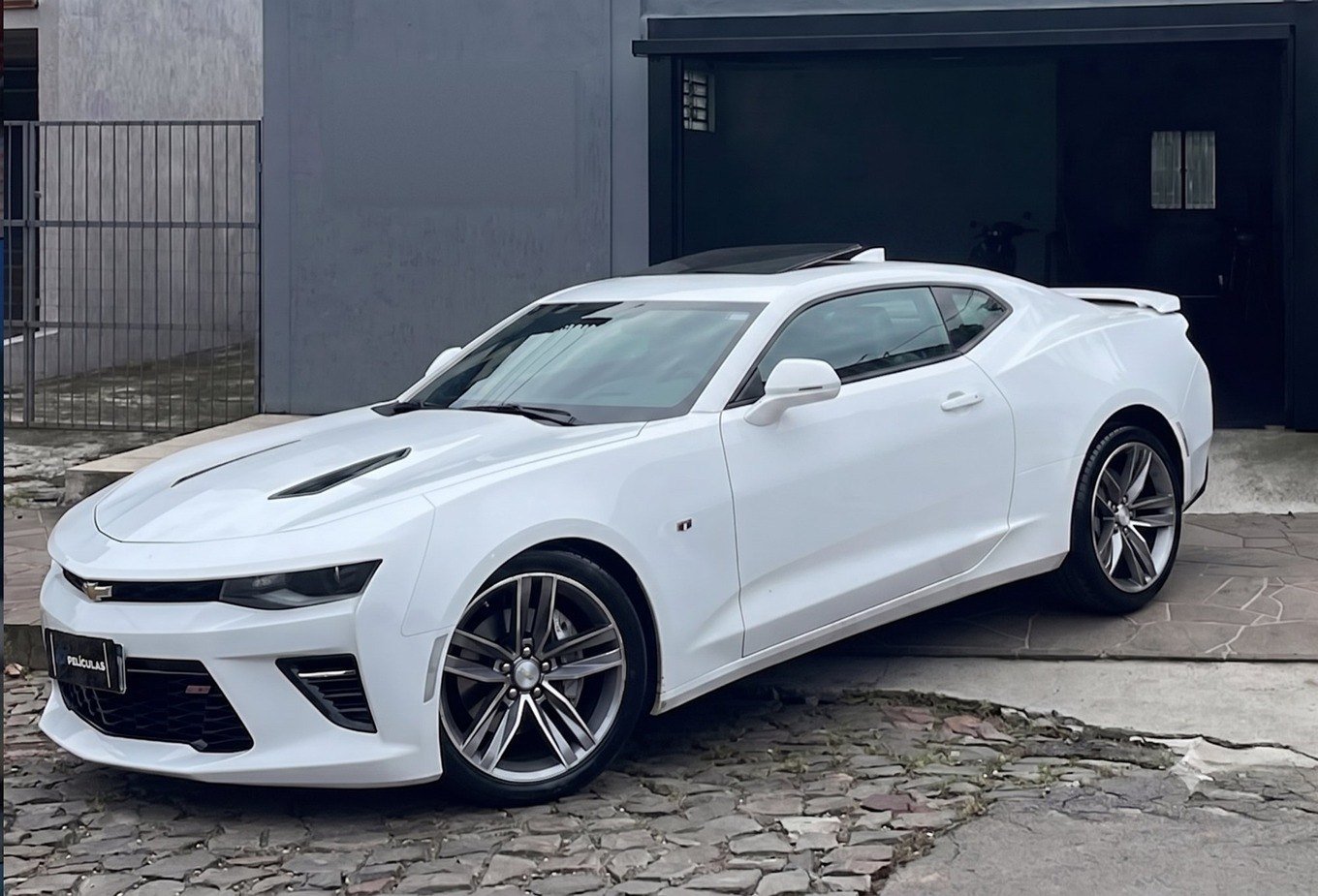 Camaro branco sem película, parado em frente à SM Películas
