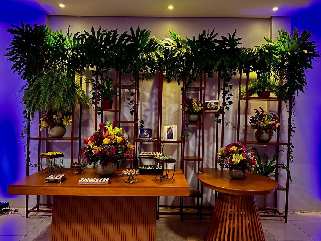 Cenário do Espaço 846 montado com plantas, luzes e mesa de doces