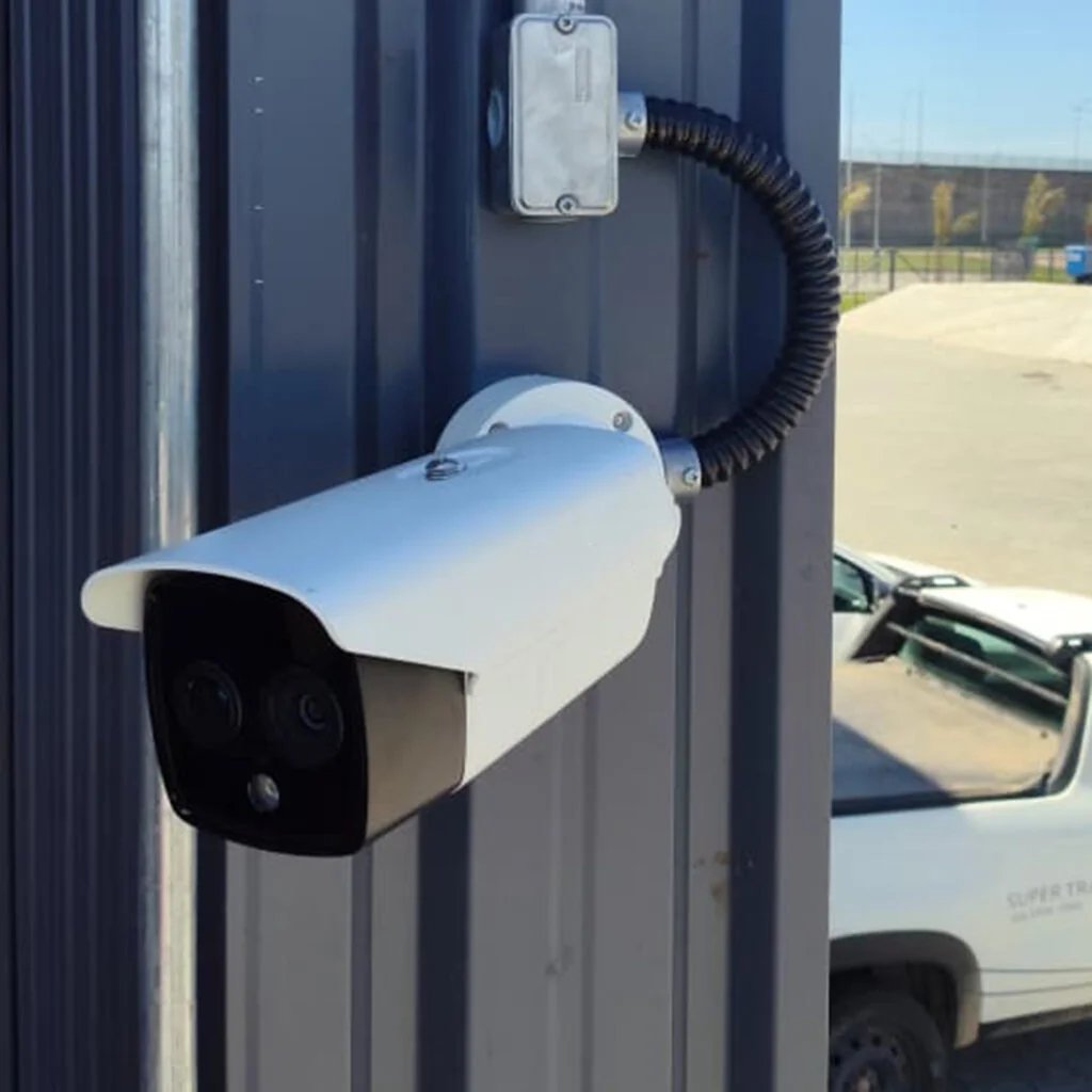 Câmera instalada em parede externa, com a frota da PRS ao fundo