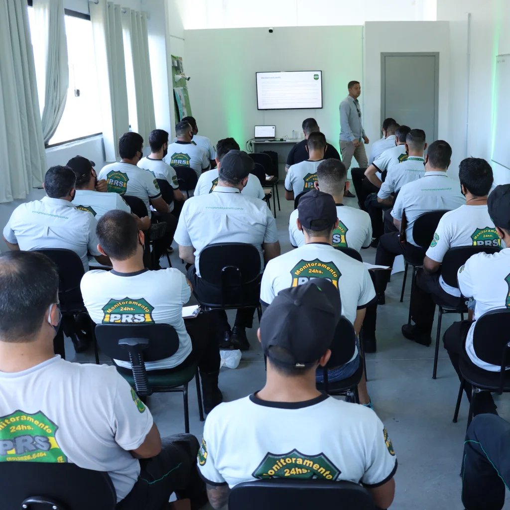Sala de treinamento da PRS cheia, com equipe uniformizada assistindo a uma capacitação